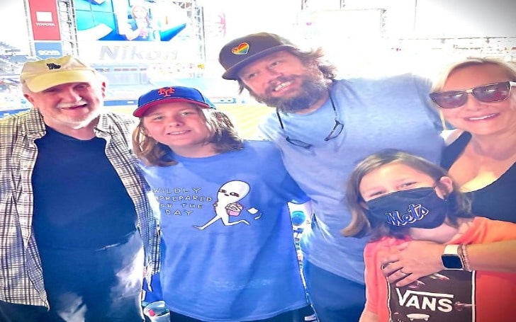 Nicole Sullivan smiling in goggles with her husband and children in blue t-shirts.